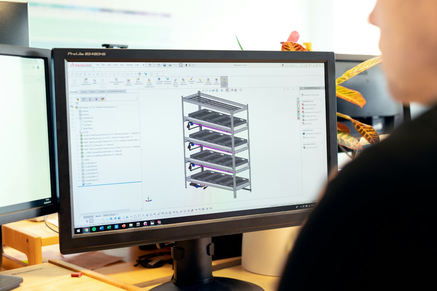 Designer working on 3D model of vertical farm shelving unit.